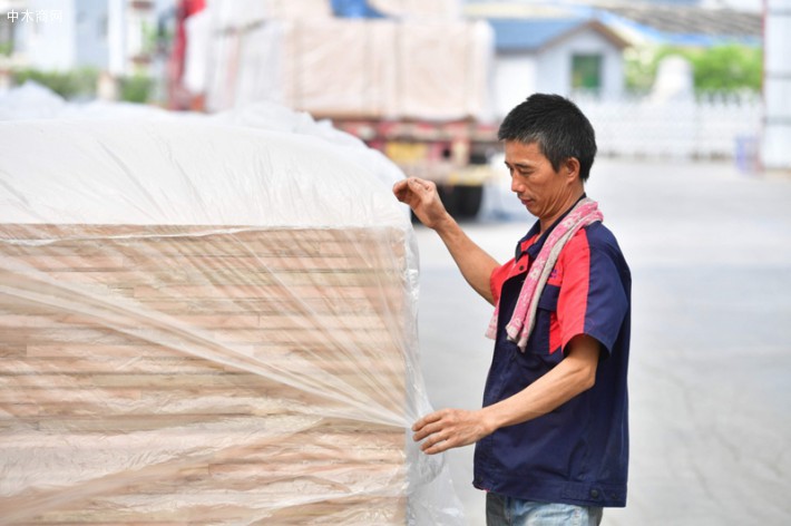 在广西鹿寨县广西桂中现代林业科技产业园一家林木加工企业，戴运明在打包木材产品